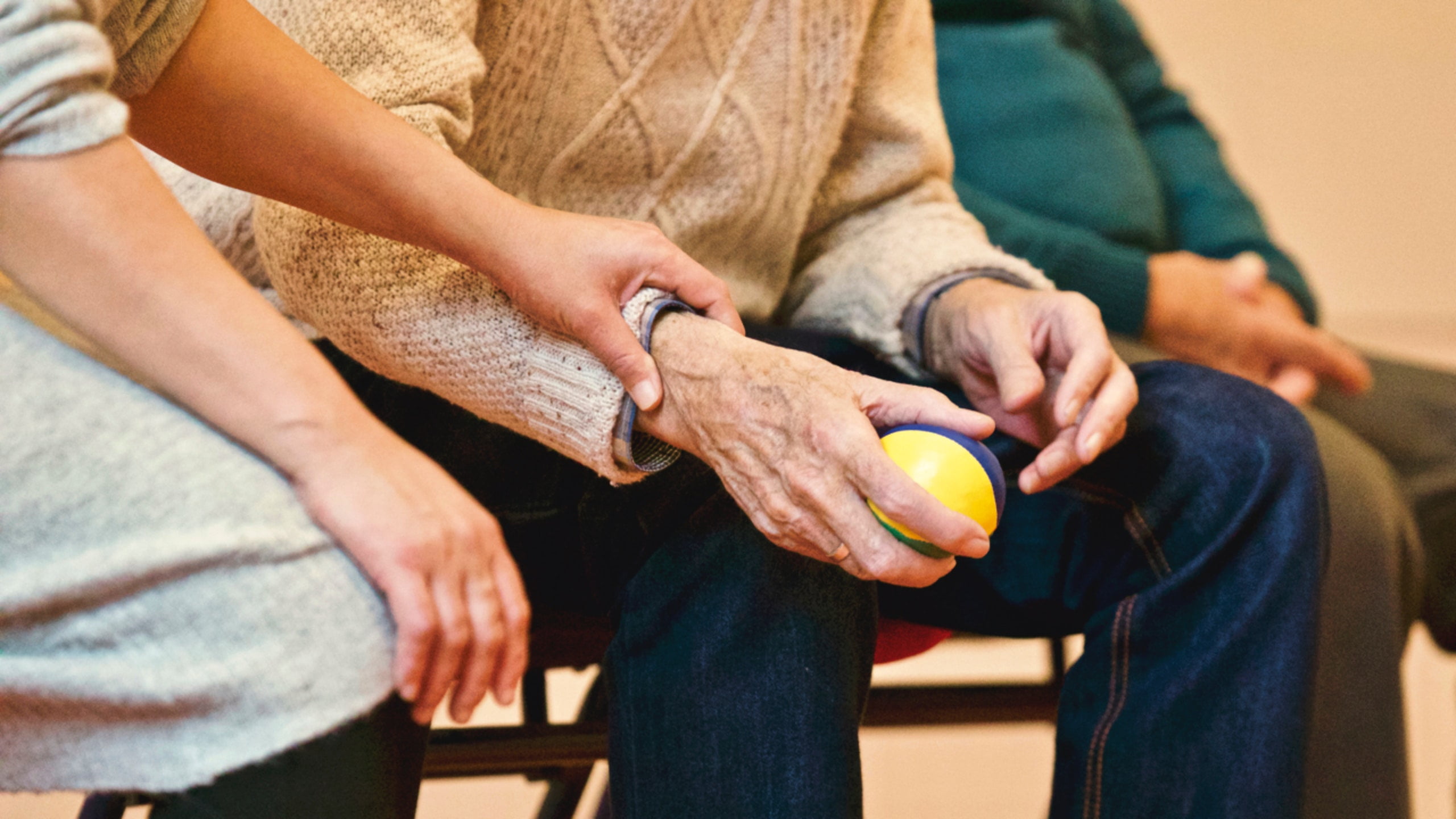 An elderly person holding a ball